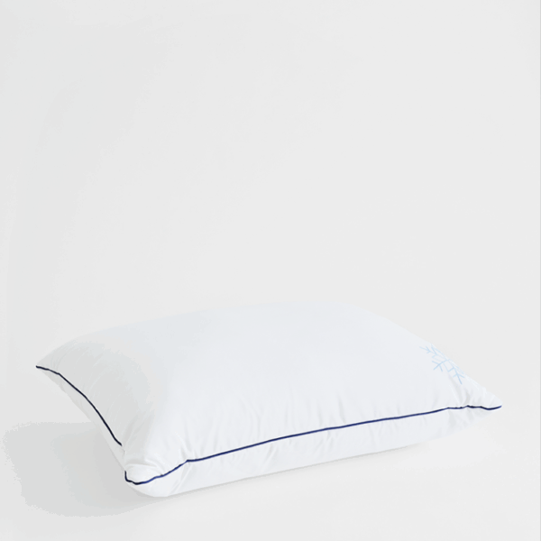 Angled view of white cooling pillow protector showing edge seam and breathable surface